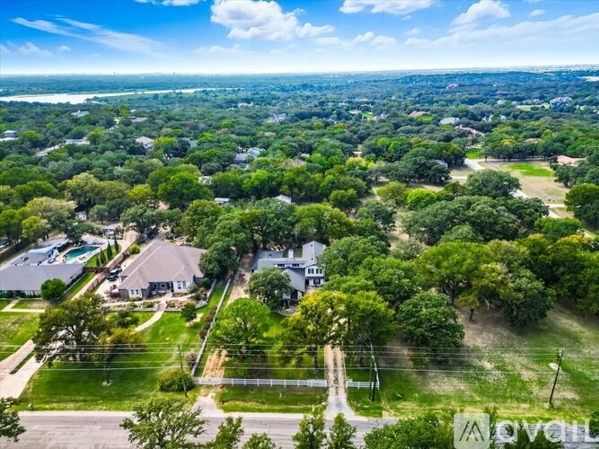 A bird's eye view of a residential area with houses surrounded by greenery.