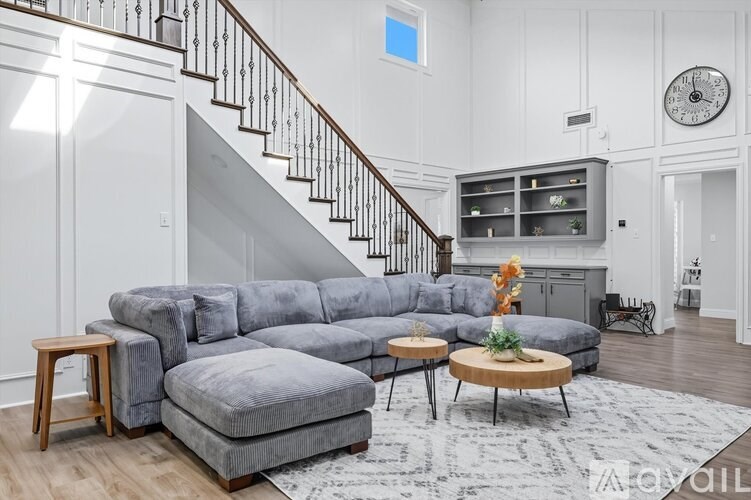 A living room with a grey sectional sofa and a wooden coffee table.