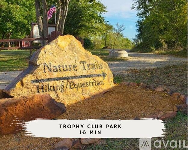 A stone sign that says Nature Trails is in front of a tree.