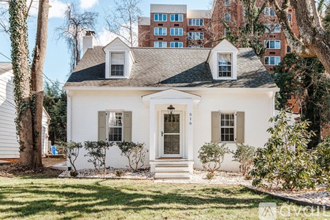 A white house with a black roof and a brown door.