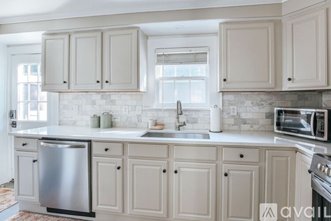 A kitchen with white cabinets and a stainless steel dishwasher.