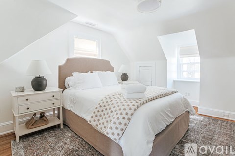 A bedroom with a bed, nightstand, and lamp.