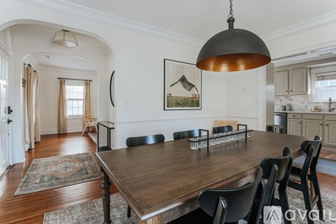 A dining room with a wooden table and chairs.