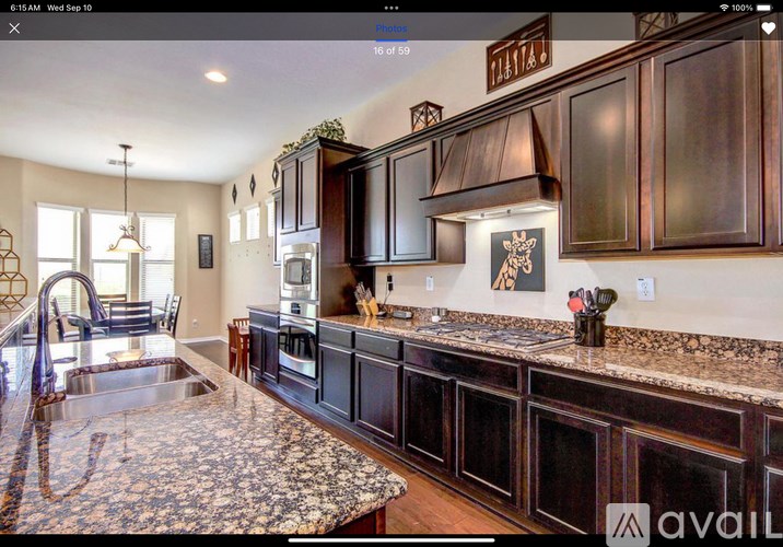 A kitchen with dark wood cabinets and granite countertops.