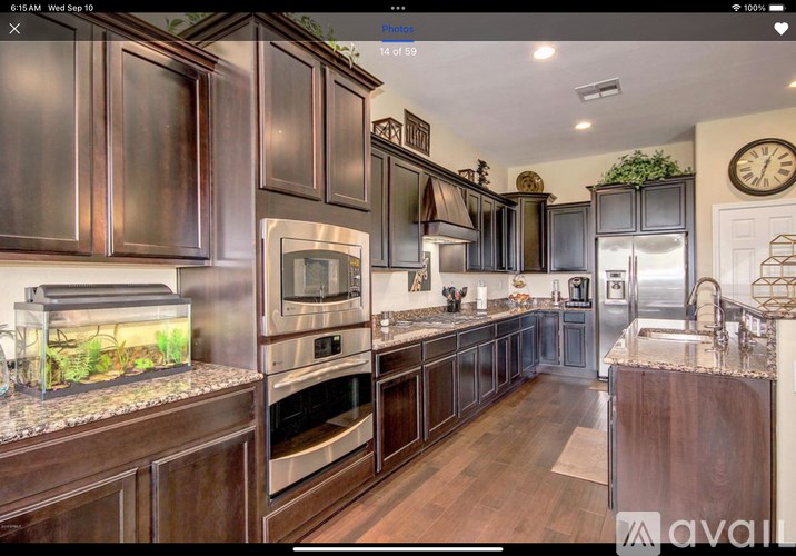 A kitchen with dark wood cabinets and stainless steel appliances.