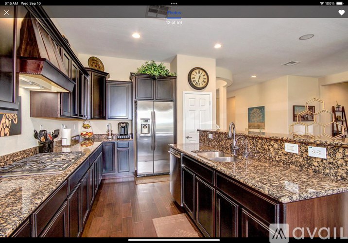 A kitchen with dark wood cabinets and granite countertops.