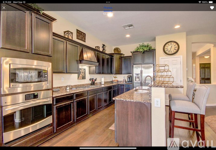 A modern kitchen with dark wood cabinets and stainless steel appliances.