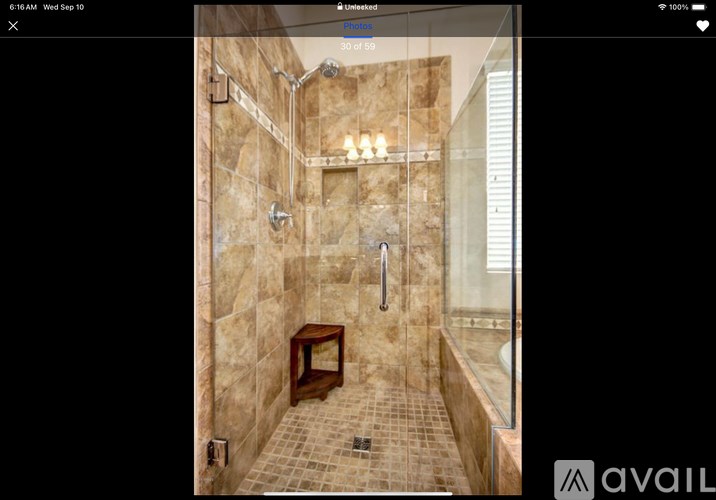 A shower area with a bench and tiled floor.