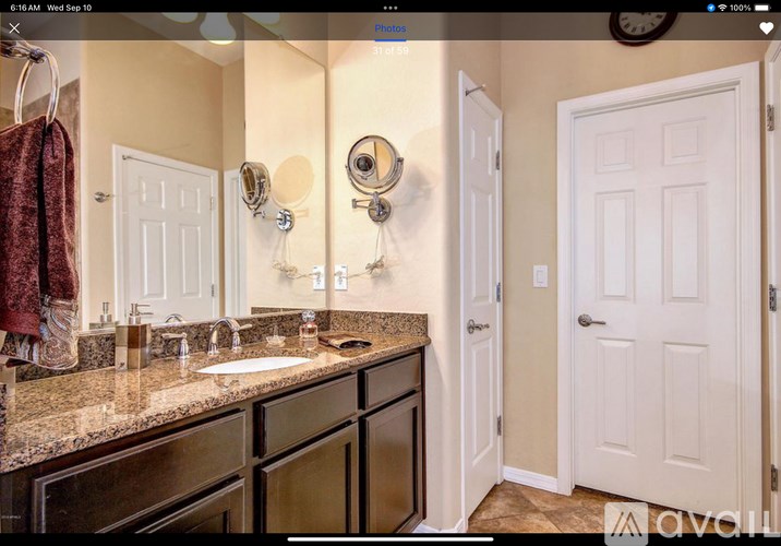A bathroom with a double sink vanity and a mirror above it.