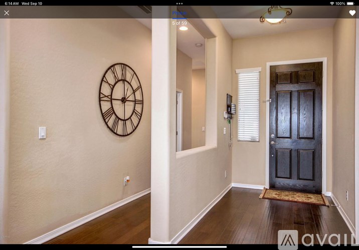A hallway with a clock on the wall and a door at the end.