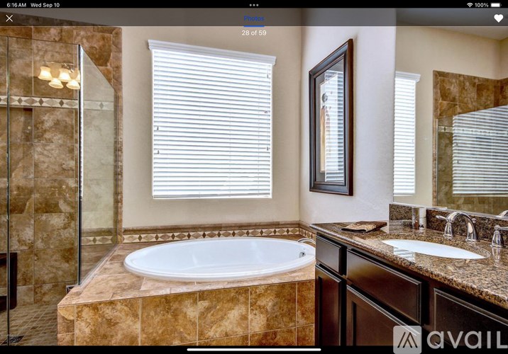 A bathroom with a tub, sink, and mirror.