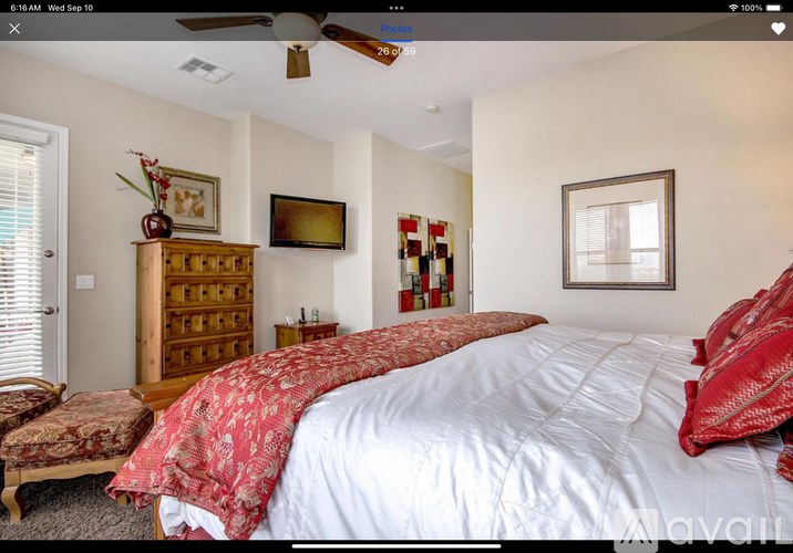 A bedroom with a large bed and a wooden chest of drawers.