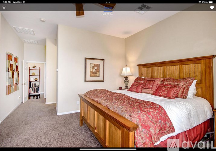 A bedroom with a large bed and a ceiling fan.