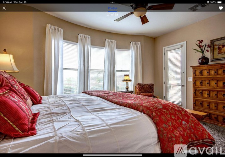 A bedroom with a large bed and a ceiling fan.