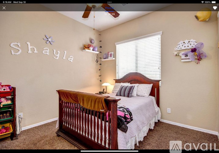 A bedroom with a bed, a dresser, and a ceiling fan.