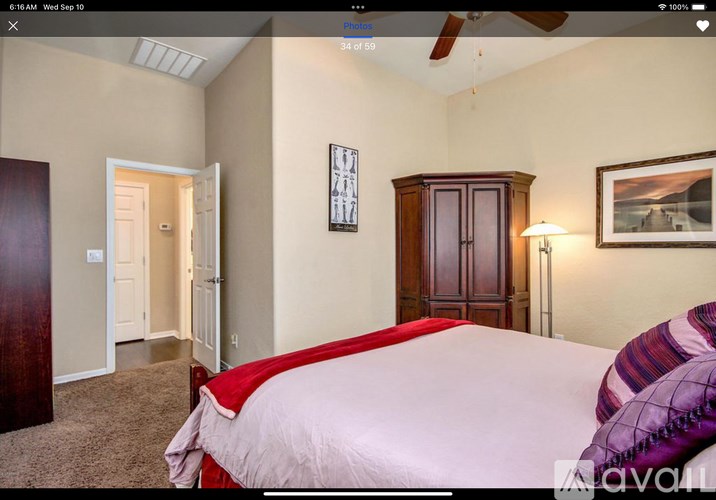 A bedroom with a bed, dresser, and ceiling fan.