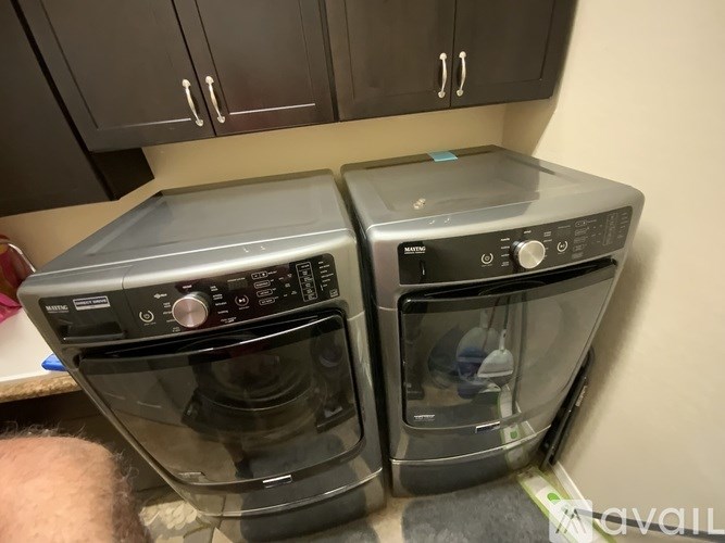Two front loading washing machines in a kitchen.