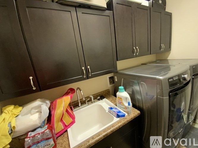A kitchen with a sink, dishwasher, and cabinets.