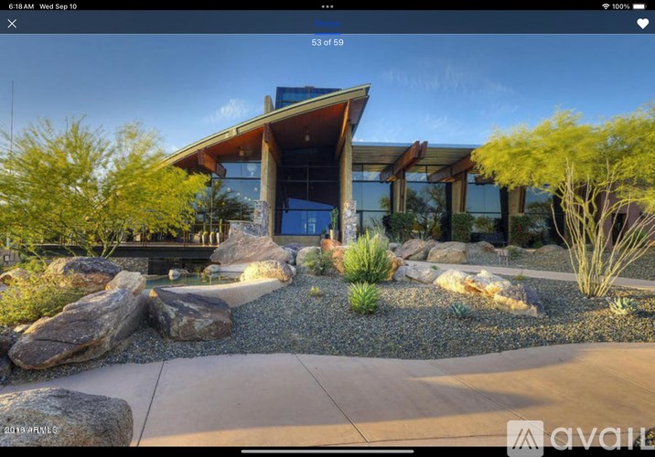 A modern house with a large front yard and a clear sky.