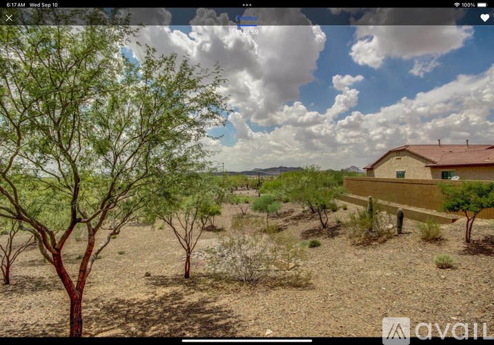A house with a red roof is surrounded by trees and bushes.