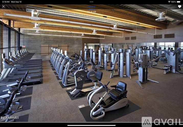 A gym with a variety of exercise equipment including treadmills, stationary bikes, and weight machines.
