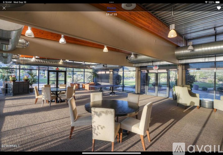 A modern dining area with a glass wall and wooden ceiling.