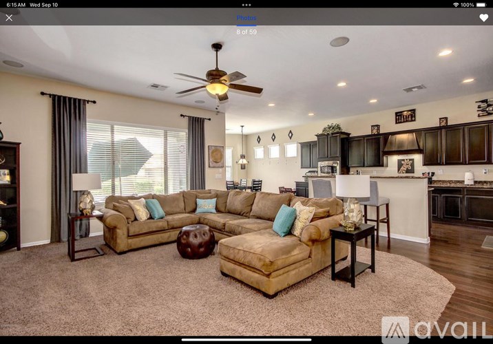 A living room with a beige sofa and a brown ottoman.