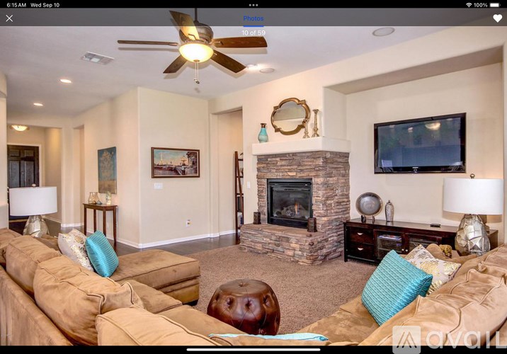 A living room with a fireplace and a television on the wall.