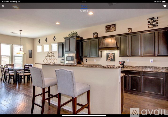 A kitchen with dark wood cabinets and a white island.