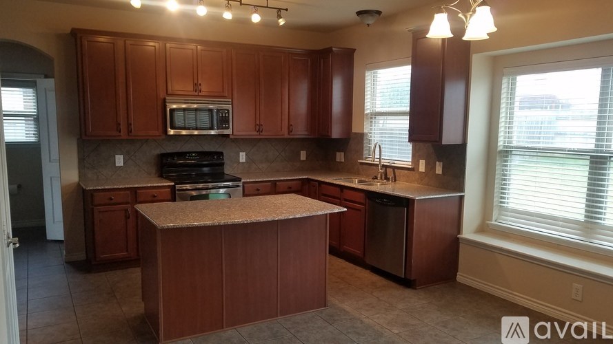 A kitchen with brown cabinets and a granite countertop.