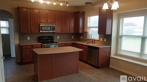 A kitchen with brown cabinets and a granite countertop.