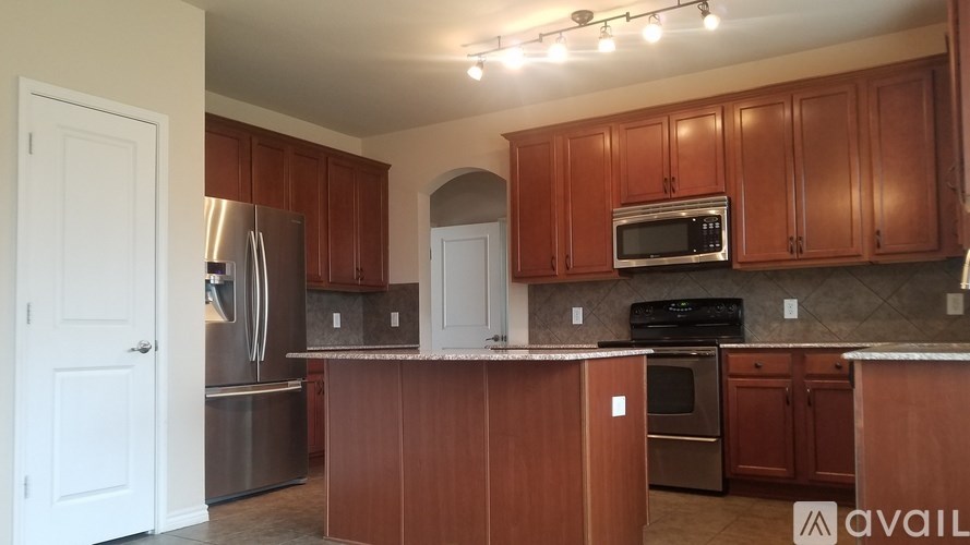 A kitchen with wooden cabinets and a refrigerator.