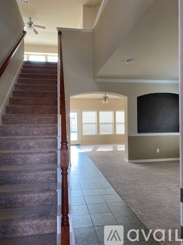 A staircase with a carpeted floor and a television in the background.