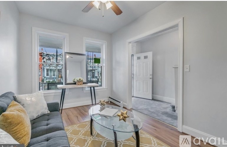 A living room with a grey couch and a glass coffee table.