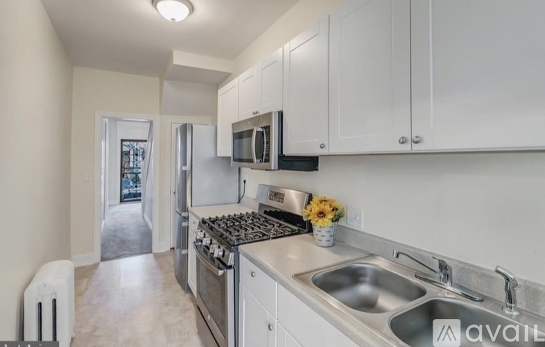 A kitchen with white cabinets and a stainless steel stove top.