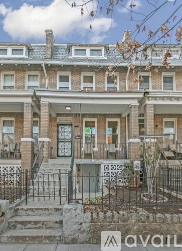 A brick building with a black fence in front.