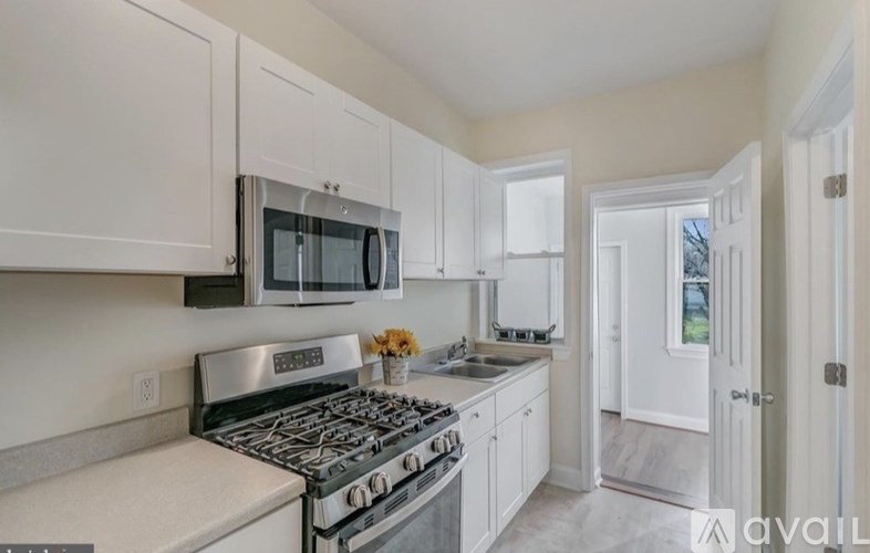 A kitchen with white cabinets and a stainless steel stove top.