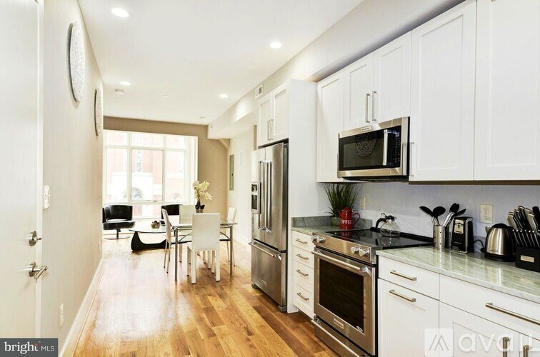 A modern kitchen with white cabinets and stainless steel appliances.