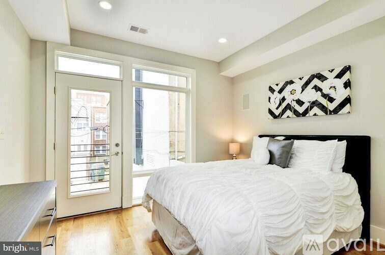 A bedroom with a large bed and a view of the outside.