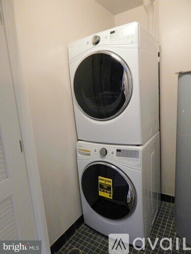 A white washer and dryer stacked on top of each other in a small room.