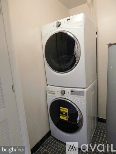 A white washer and dryer stacked on top of each other in a small room.