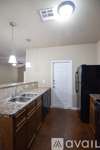 A kitchen with a sink, refrigerator, and cabinets.