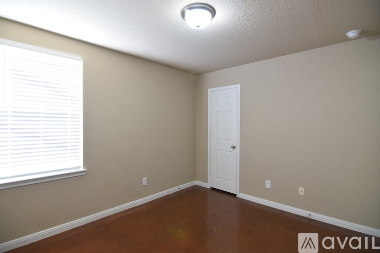 A room with a white door and a window with blinds.
