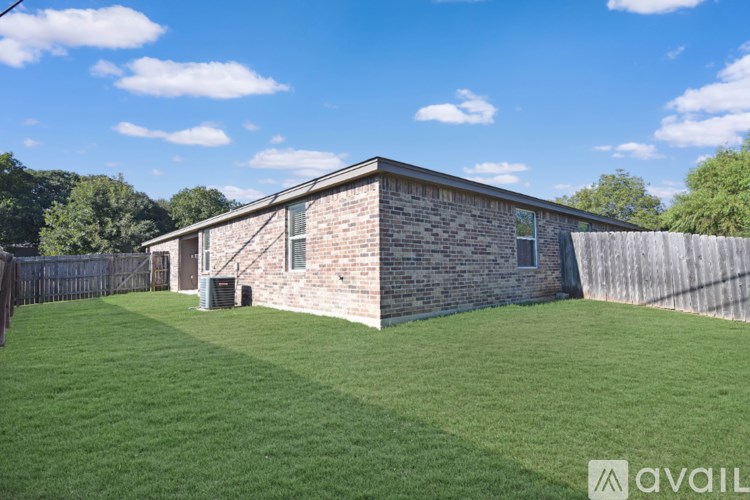 A brick house with a fence in front of it.