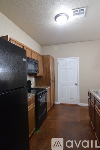 A kitchen with black appliances and wooden cabinets.