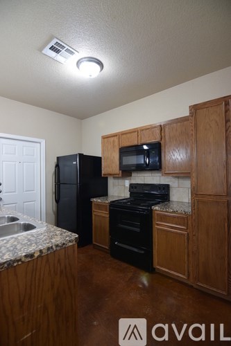 A kitchen with wooden cabinets and black appliances.