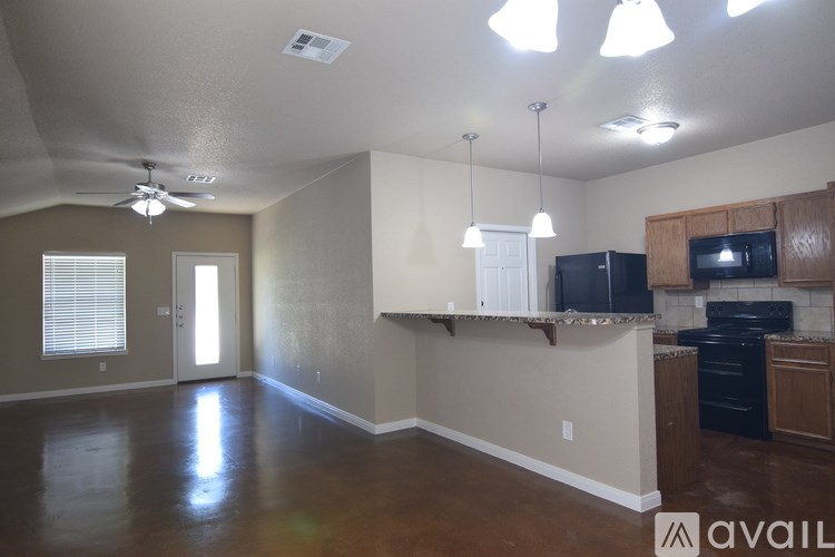 A kitchen area with a black fridge, microwave, and oven.