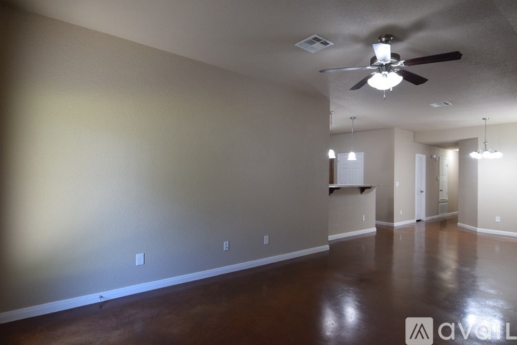 A spacious room with a ceiling fan and wooden flooring.