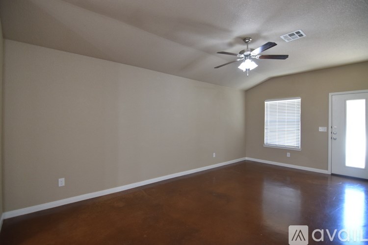 A room with a ceiling fan and wooden flooring.