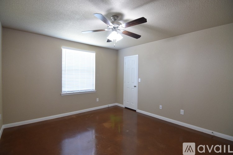 A room with a ceiling fan and a door.